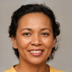 Joyful latino adult female with medium  brown hair and brown eyes