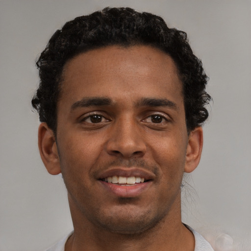Joyful black young-adult male with short  brown hair and brown eyes