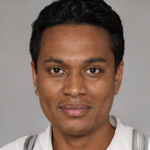 Joyful black young-adult male with short  black hair and brown eyes