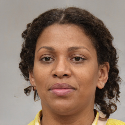 Joyful black adult female with medium  brown hair and brown eyes