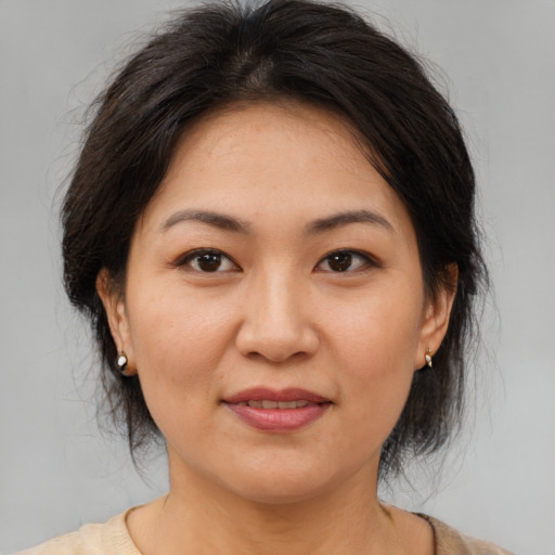 Joyful asian adult female with medium  brown hair and brown eyes