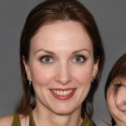 Joyful white adult female with medium  brown hair and blue eyes