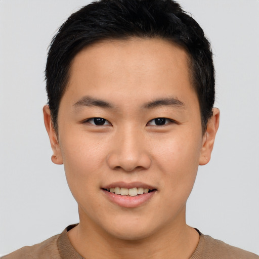 Joyful asian young-adult male with short  black hair and brown eyes