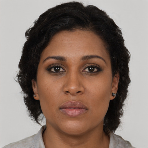Joyful black young-adult female with medium  brown hair and brown eyes