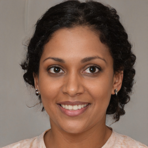 Joyful black young-adult female with medium  brown hair and brown eyes