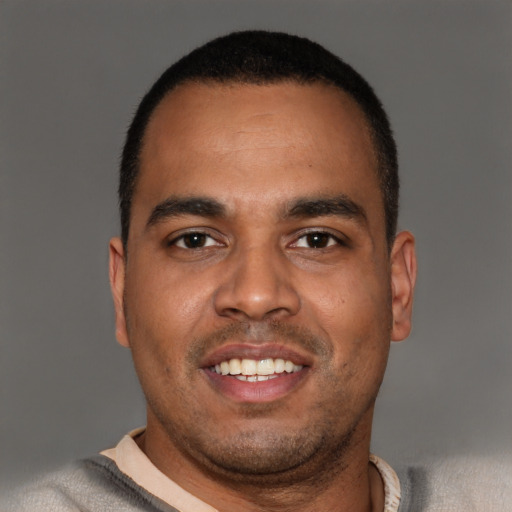 Joyful black young-adult male with short  brown hair and brown eyes