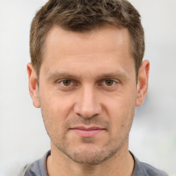 Joyful white adult male with short  brown hair and grey eyes