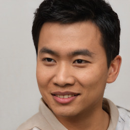 Joyful asian young-adult male with short  brown hair and brown eyes