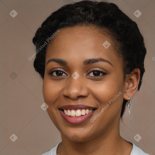 Joyful black young-adult female with long  black hair and brown eyes