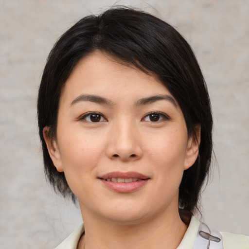 Joyful asian young-adult female with medium  black hair and brown eyes