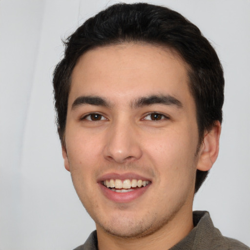 Joyful white young-adult male with short  black hair and brown eyes