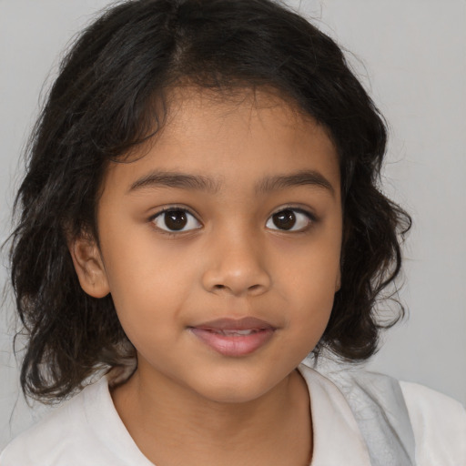 Joyful latino child female with medium  brown hair and brown eyes