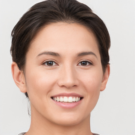 Joyful white young-adult female with short  brown hair and brown eyes