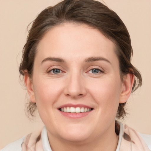 Joyful white young-adult female with medium  brown hair and blue eyes