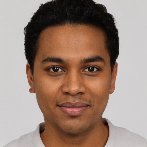 Joyful black young-adult male with short  black hair and brown eyes