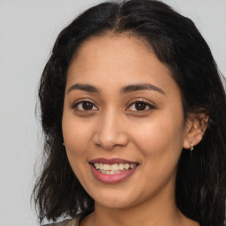 Joyful latino young-adult female with long  brown hair and brown eyes