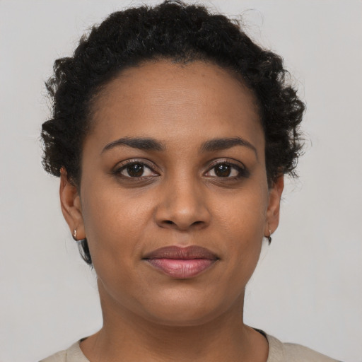 Joyful black young-adult female with short  brown hair and brown eyes