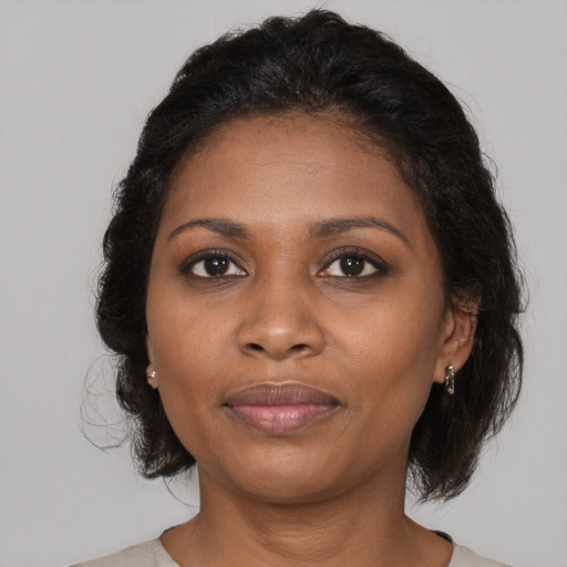 Joyful black young-adult female with medium  brown hair and brown eyes