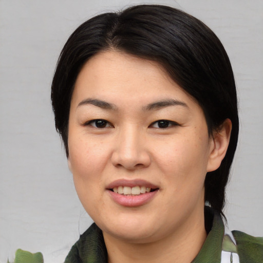 Joyful asian young-adult female with medium  brown hair and brown eyes