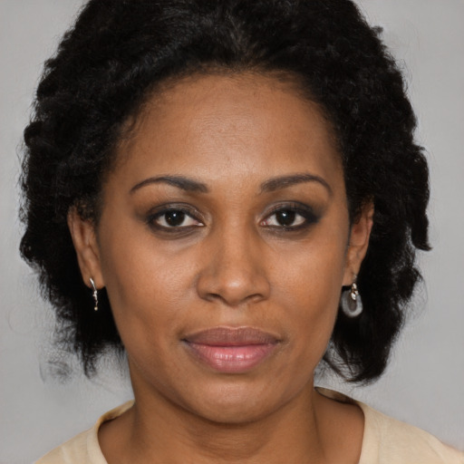 Joyful latino adult female with medium  brown hair and brown eyes