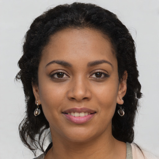 Joyful black young-adult female with long  brown hair and brown eyes