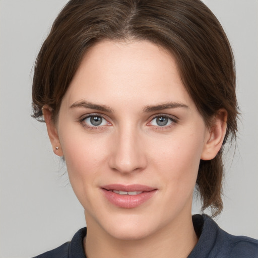 Joyful white young-adult female with medium  brown hair and grey eyes