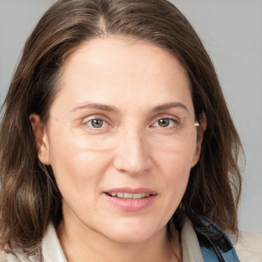 Joyful white young-adult female with medium  brown hair and grey eyes