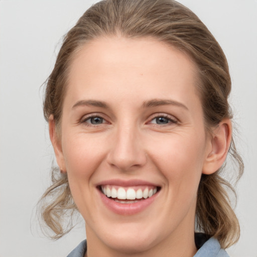 Joyful white young-adult female with medium  brown hair and grey eyes