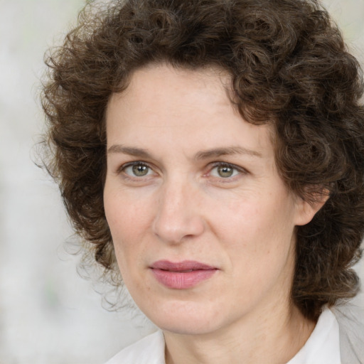 Joyful white adult female with medium  brown hair and green eyes