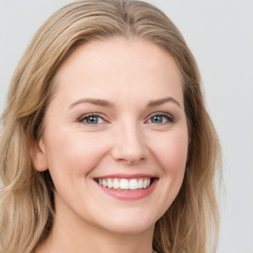 Joyful white young-adult female with long  brown hair and blue eyes