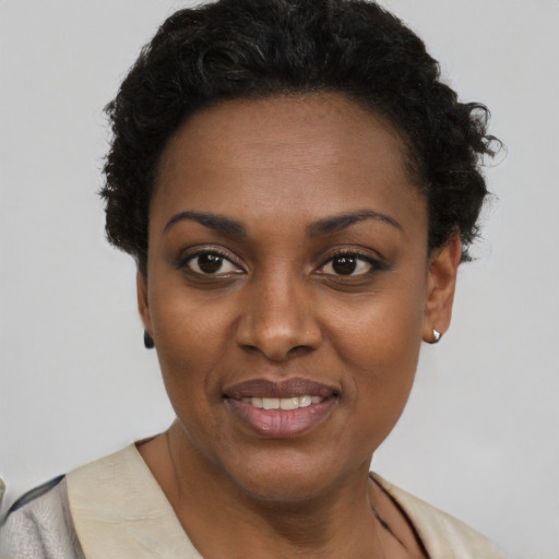 Joyful black young-adult female with short  black hair and brown eyes