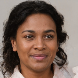 Joyful latino adult female with medium  brown hair and brown eyes