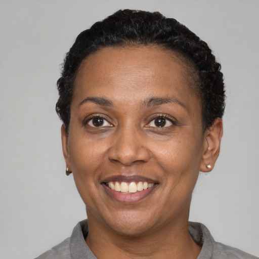 Joyful black adult female with short  black hair and brown eyes