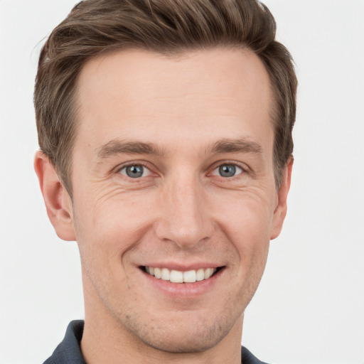 Joyful white young-adult male with short  brown hair and grey eyes