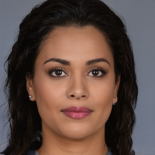 Joyful latino young-adult female with long  brown hair and brown eyes