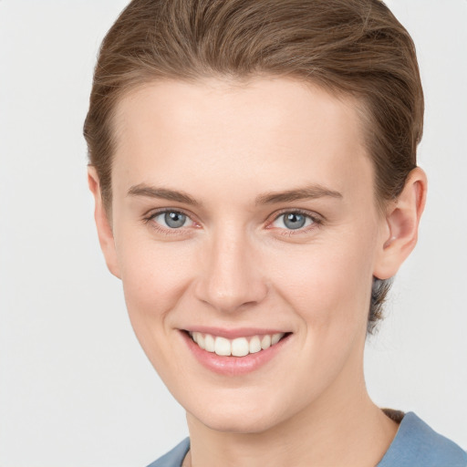 Joyful white young-adult female with short  brown hair and grey eyes