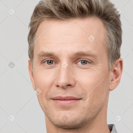 Joyful white adult male with short  brown hair and grey eyes