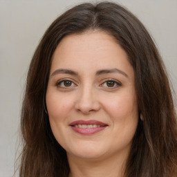 Joyful white adult female with long  brown hair and brown eyes