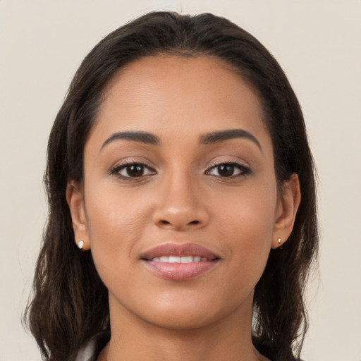 Joyful latino young-adult female with long  brown hair and brown eyes