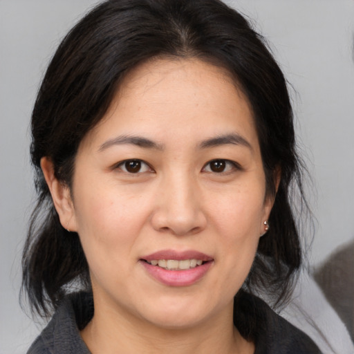 Joyful asian young-adult female with medium  brown hair and brown eyes