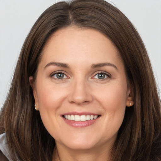 Joyful white young-adult female with long  brown hair and grey eyes