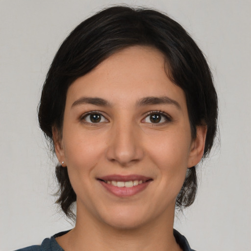 Joyful white young-adult female with medium  black hair and brown eyes