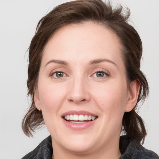 Joyful white young-adult female with medium  brown hair and blue eyes