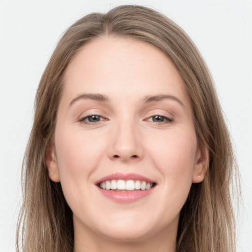 Joyful white young-adult female with long  brown hair and grey eyes