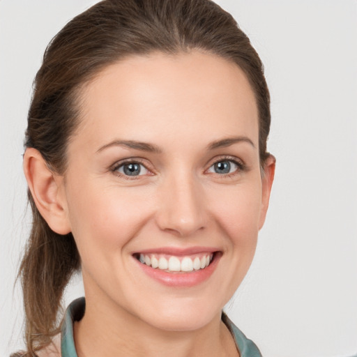 Joyful white young-adult female with long  brown hair and grey eyes