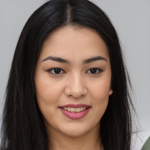 Joyful asian young-adult female with long  brown hair and brown eyes