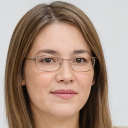 Joyful white young-adult female with long  brown hair and green eyes