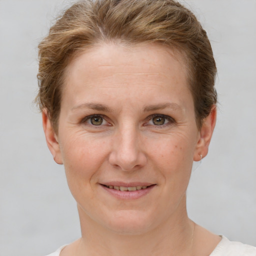 Joyful white adult female with short  brown hair and grey eyes