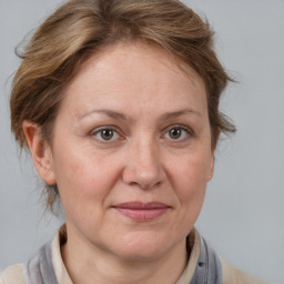 Joyful white adult female with medium  brown hair and grey eyes