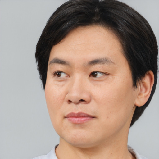 Joyful asian young-adult male with medium  brown hair and brown eyes